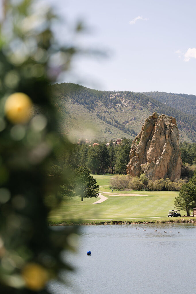 Dramatic red rock formations and golf course fairway at Colorado Front Range wedding venue with lake views