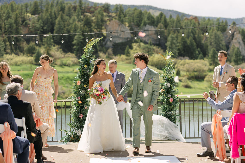 Gorgeous wedding ceremony rose petal exit at Perry Park Country Club lakeside mountain deck