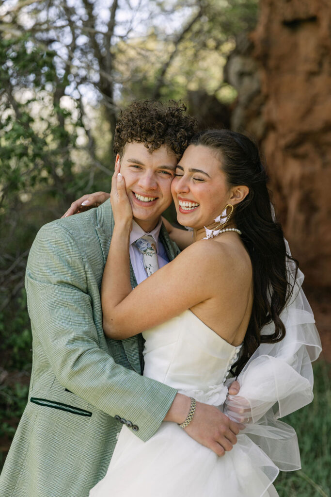 Joyous couple embracing during their outdoor wedding portraits in Colorado