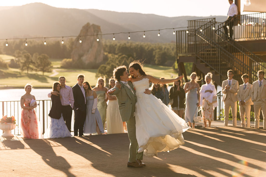 Bride and groom first dance on Perry Park Country Club covered patio with dramatic sunset lighting and Lake Wauconda views