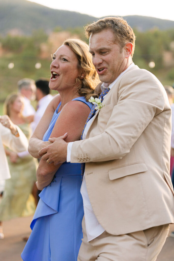 Wedding guests embracing and celebrating at Colorado mountain venue reception