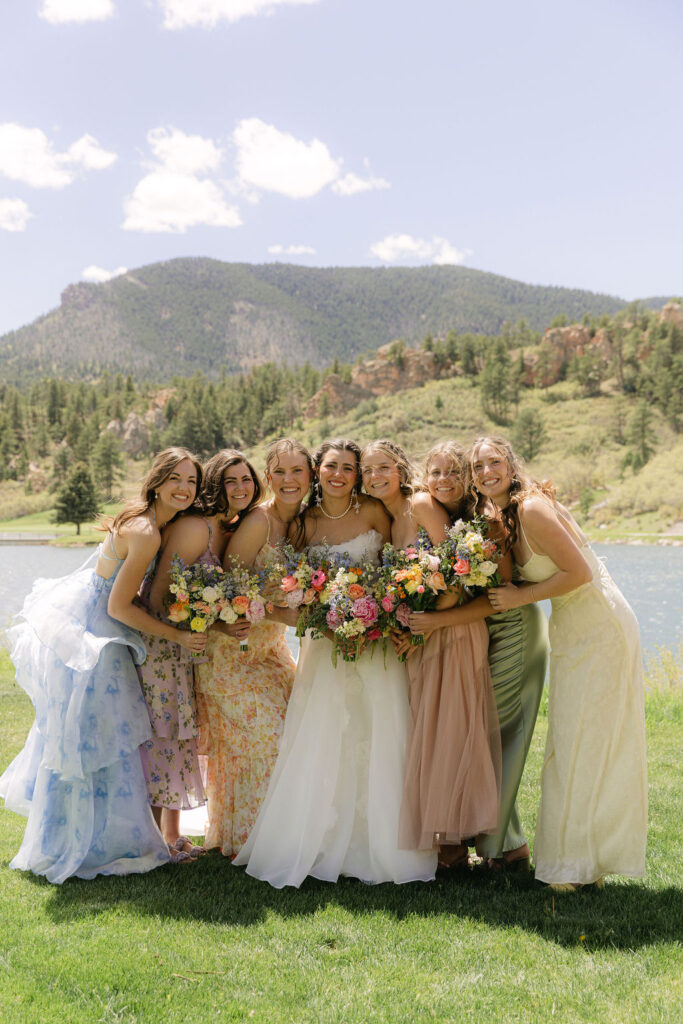 Mismatched bridesmaid dresses in soft pastels with wildflower bouquets