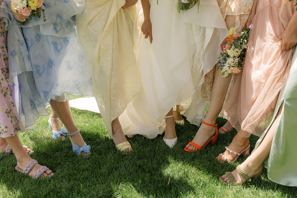 Colorful mismatched bridesmaid dresses and shoes at Perry Park Country Club wedding, featuring soft pastels, floral patterns, and garden party wedding style inspiration in Colorado