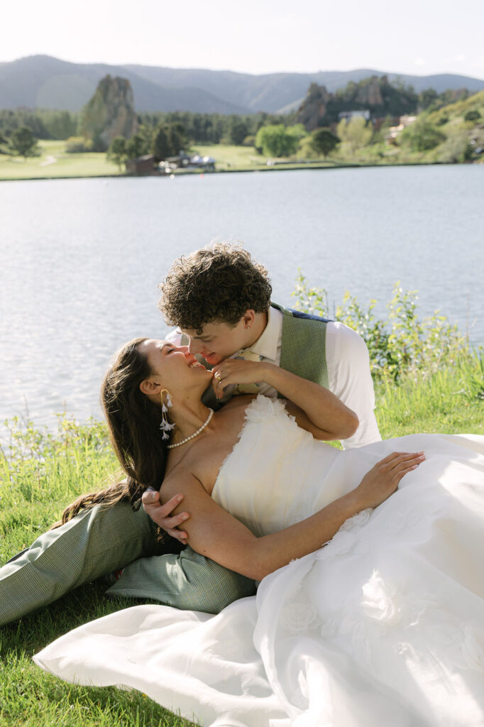 Romantic lakefront couple portrait with groom dipping bride by Lake Wauconda at Perry Park Country Club wedding in Larkspur Colorado
