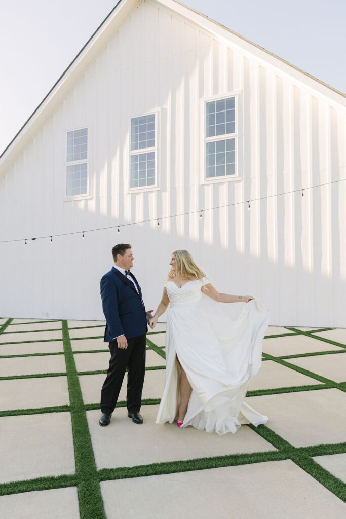 The couple twirls in front of Camp Hosea’s white chapel courtyard, captured in the soft glow of sunset light.