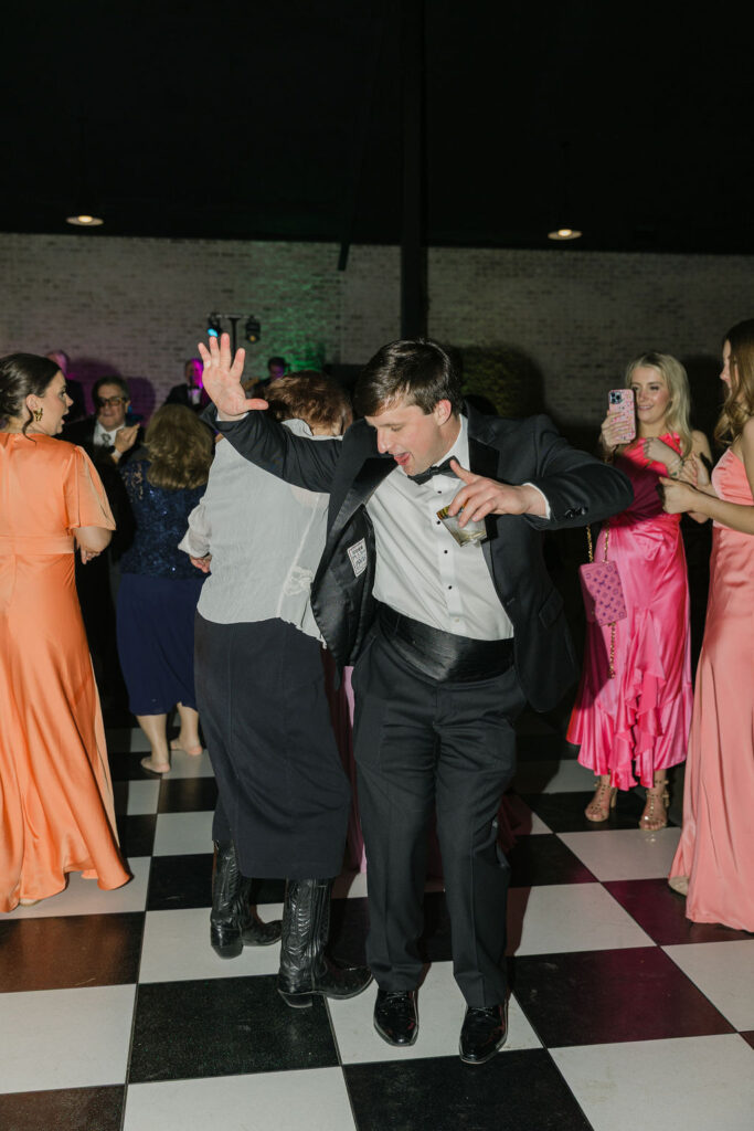 Guests throw their hands up while dancing, adding to the joyful, high-energy celebration at this Texas wedding.