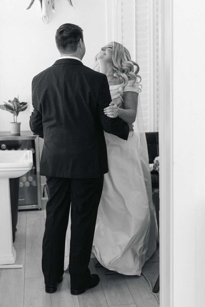 A quiet black-and-white photo of the couple sharing a sweet embrace, just after walking out of their wedding ceremony in this modern Texas venue.