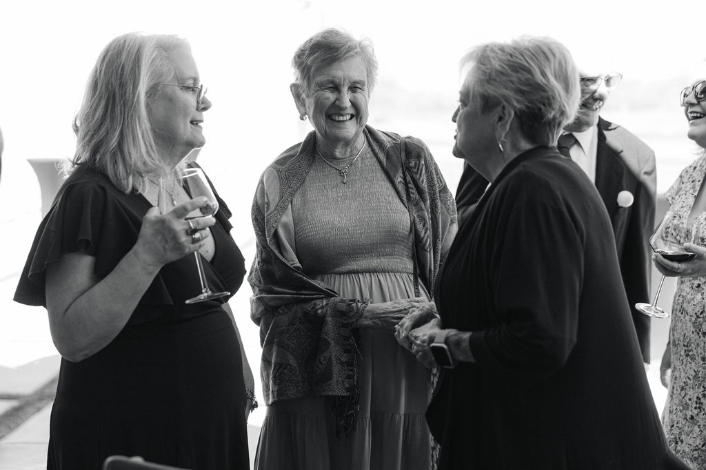 A black-and-white candid of guests sharing a sweet moment during the reception, capturing the timeless charm of this Texas wedding day.