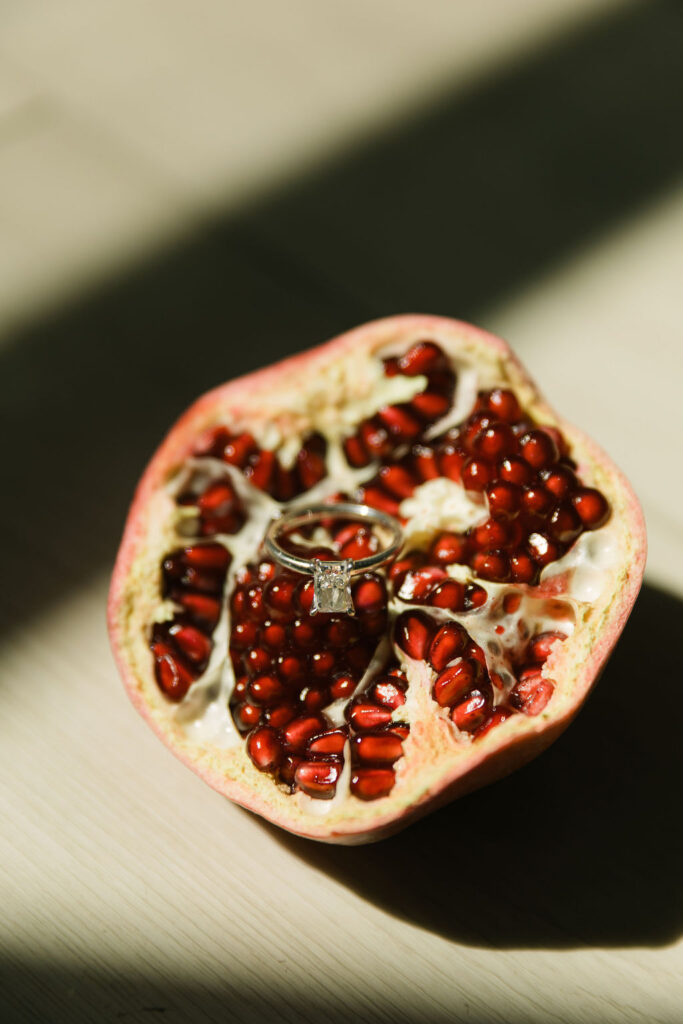 A close-up of a halved pomegranate glistens with seeds—part of the fruit-forward wedding details at this vibrant Houston wedding.