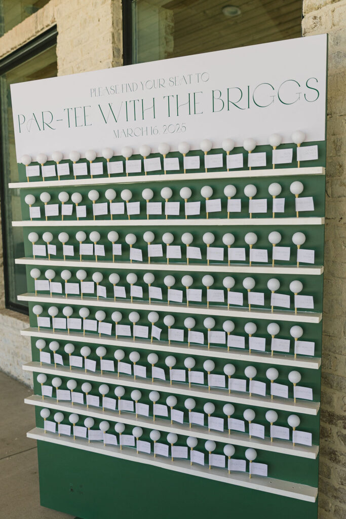 A seating chart wall filled with white golf balls and calligraphed cards reads “Par-Tee With the Briggs,” blending fun and elegance at this modern Texas wedding.
