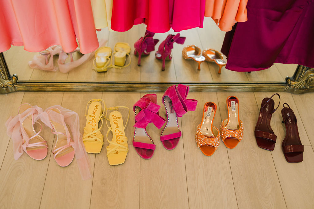 A close-up of colorful wedding shoes in bright yellow, fuchsia, and tangerine, showcasing fun and playful style at this modern Texas wedding.