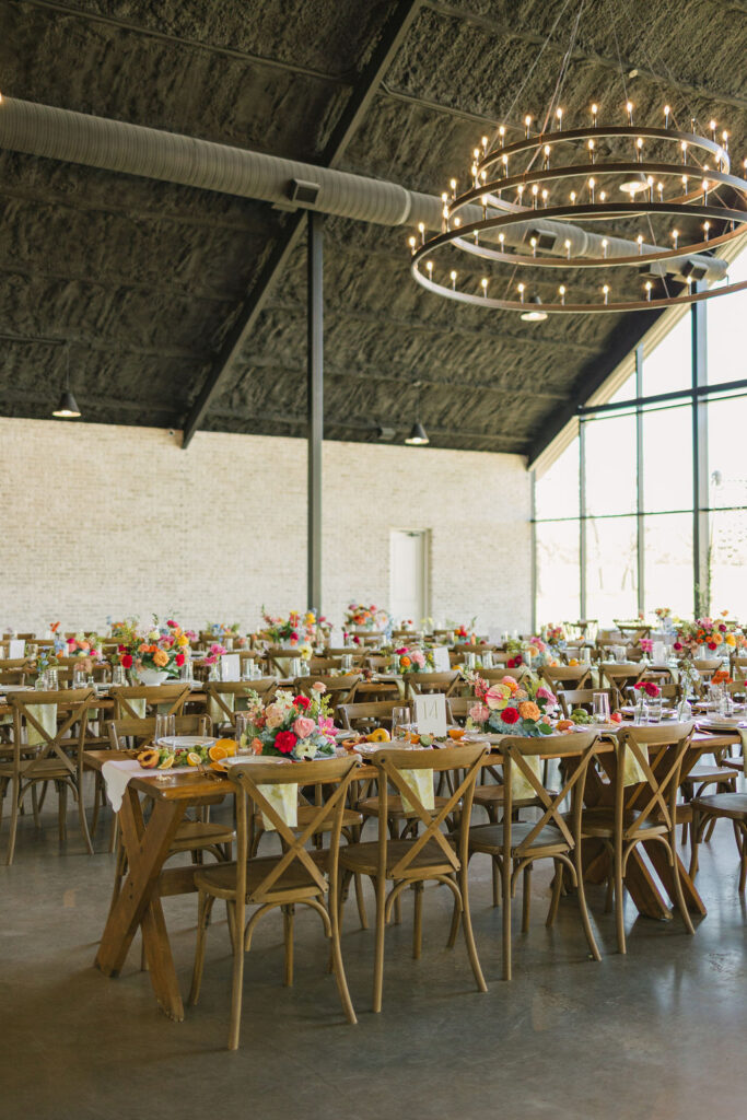 A dramatic view of Camp Hosea’s iconic chandeliers hanging above the dance floor, captured in warm ambient lighting.