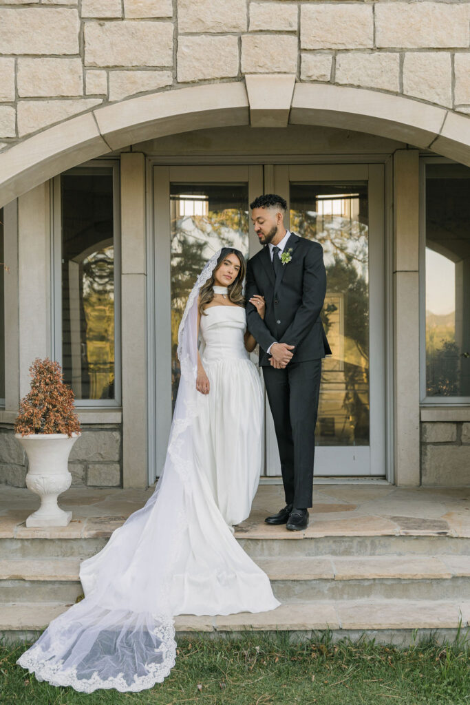 bride and groom posing outside of Greystone Castle