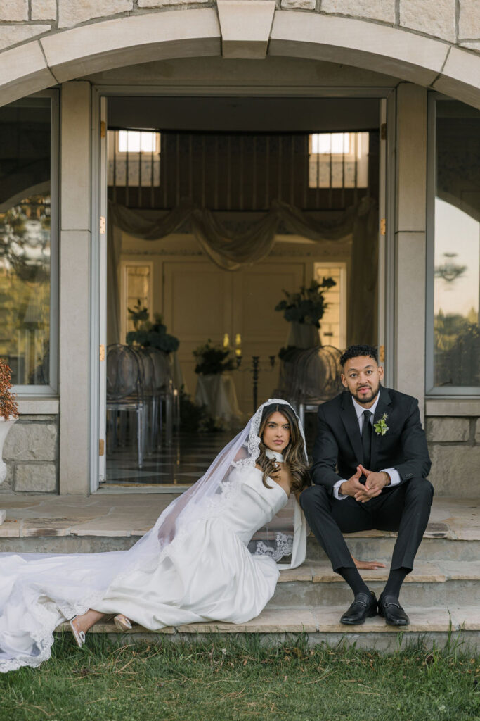 Bride and groom sitting outside on the porch during their Greystone Castle wedding in Colorado
