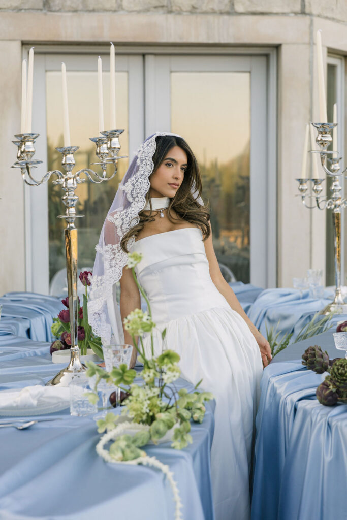 bride posing surrounded by the reception tables
