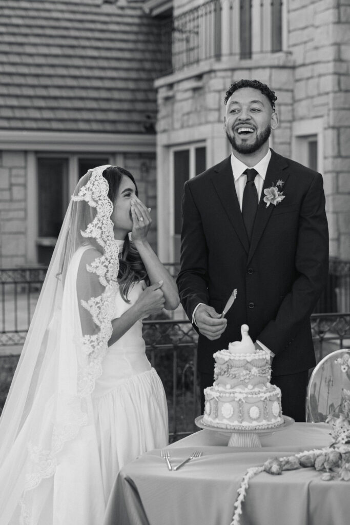 candid moment of bride and groom cutting their cake
