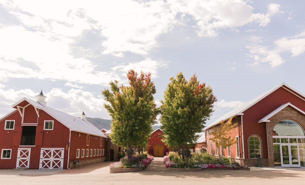 the lush garden and red barn style building at The Venue at Crooked Willow Farms
