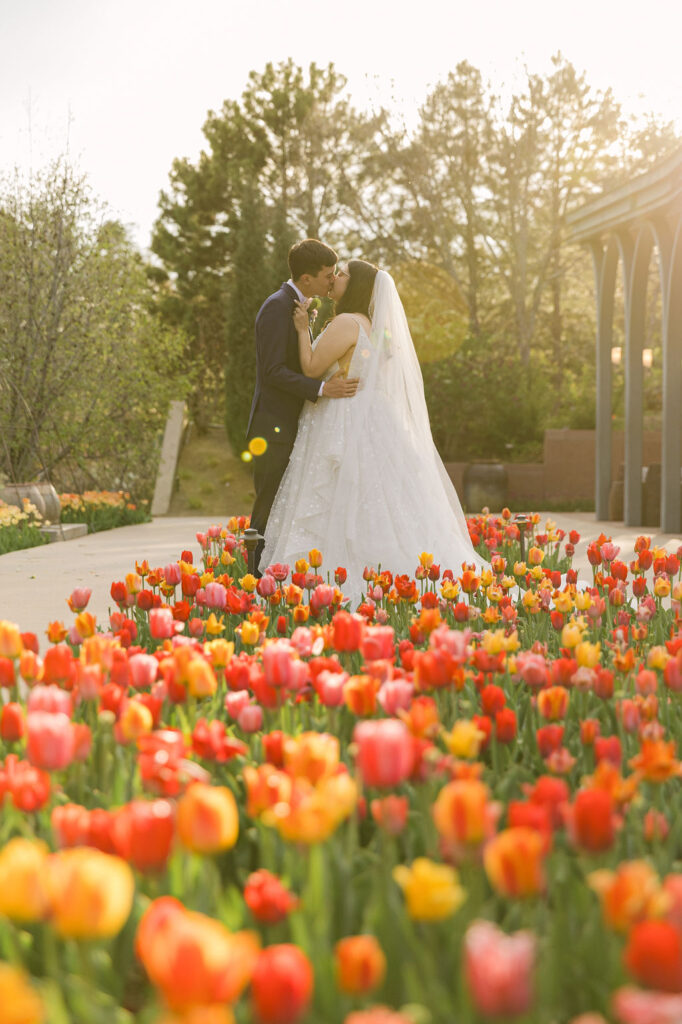 bride and groom surrounded by colorful tulips at a garden wedding venue in Colorado