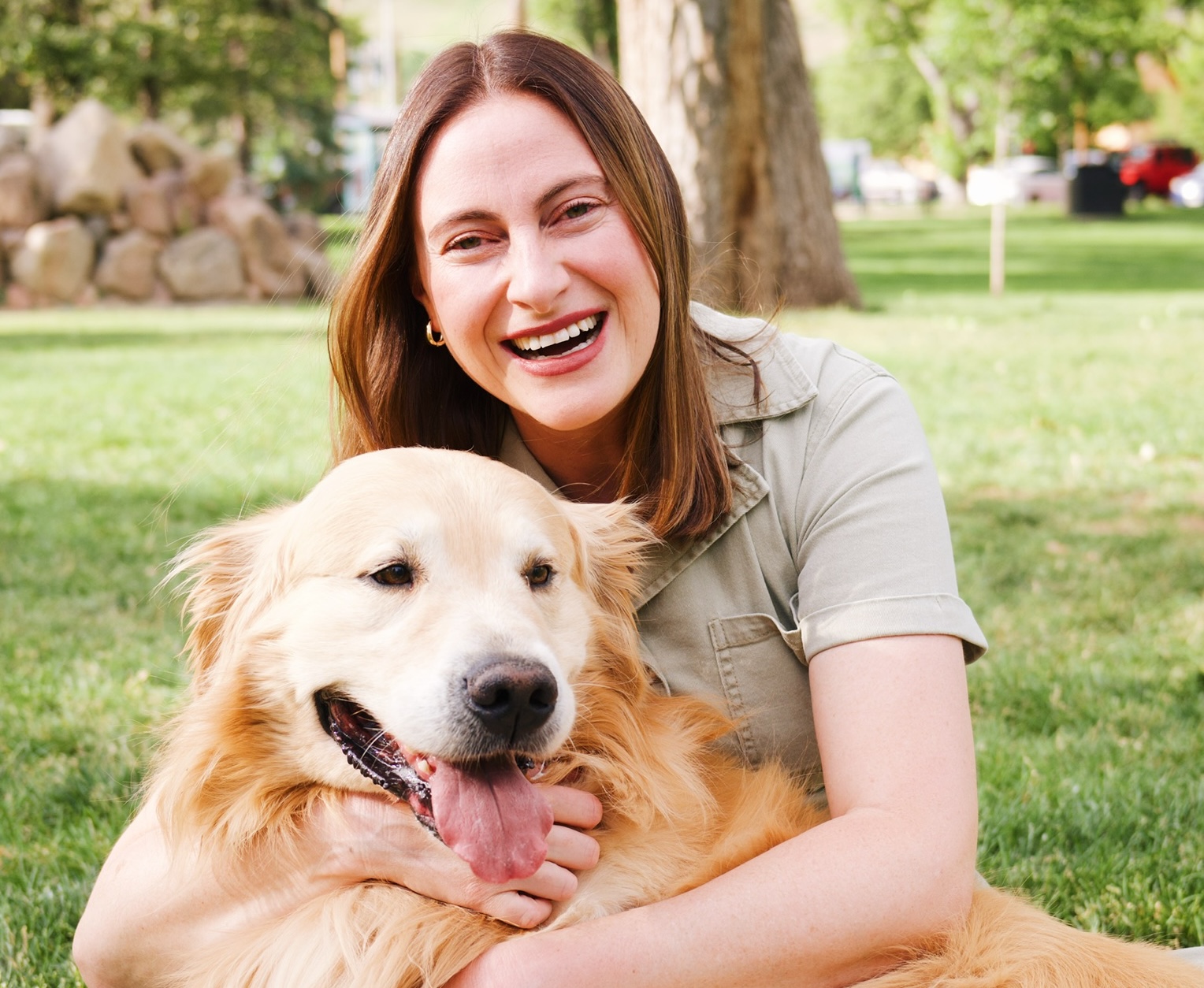 Portrait of Colorado wedding pet attendant Lauren of Pets of Honor with her golden retriever Phil laying on the lawn