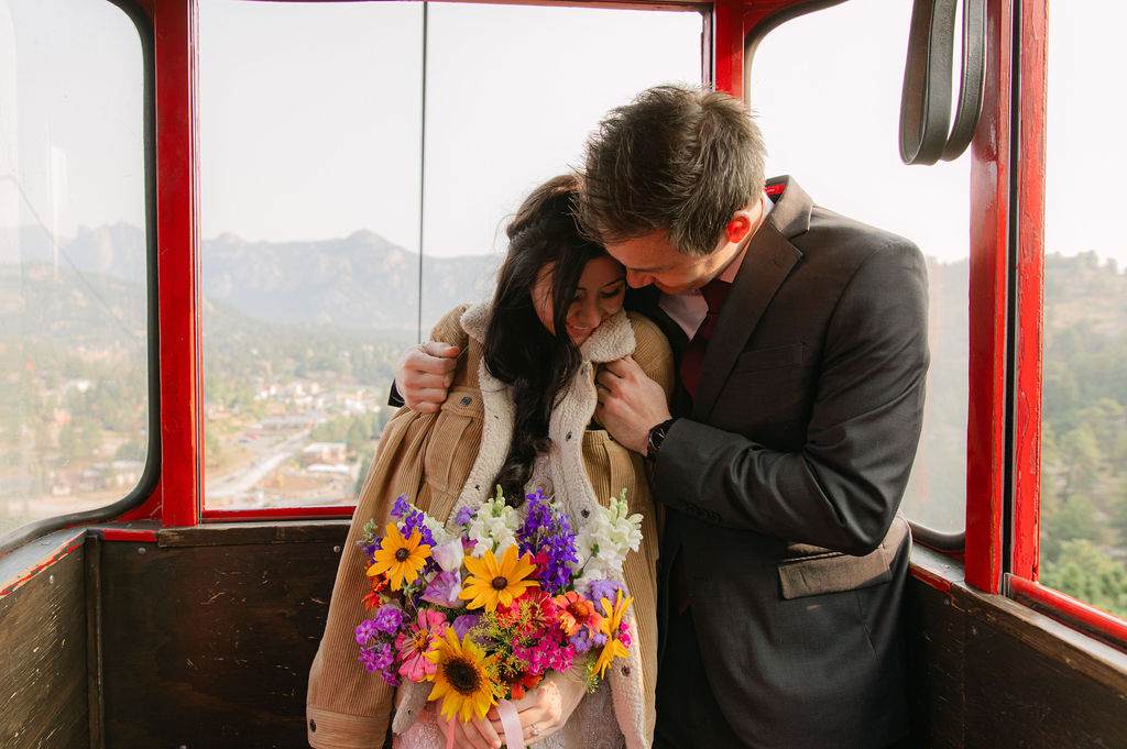 romantic bride and groom inside a Estes park aerial tram