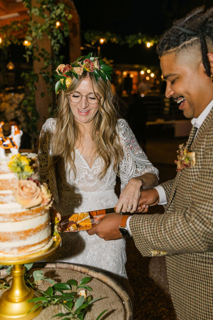 happy bride and groom cutting their wedding cake at the venue on the rocks