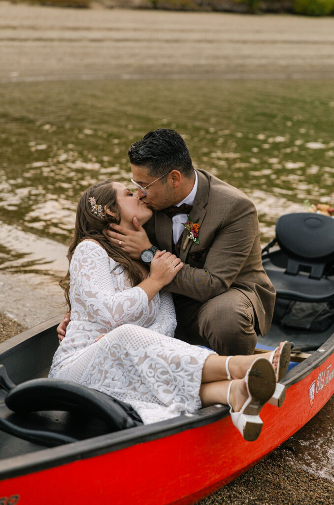 bride and groom kissing in a boat