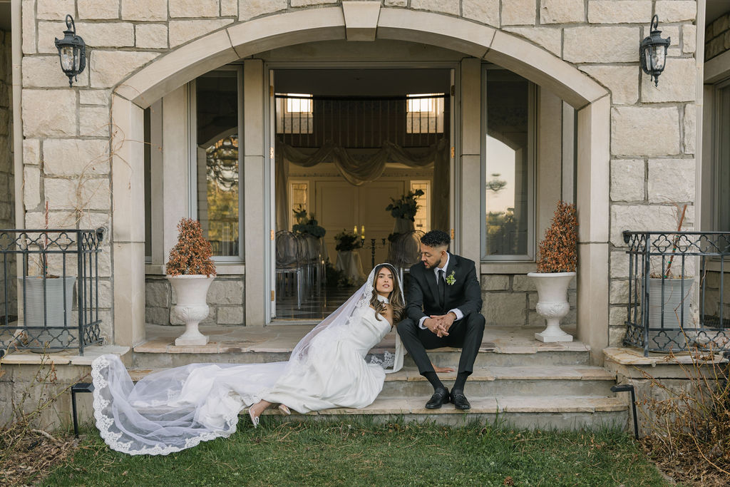 bride and groom sitting in front of the greystone castle wedding venue