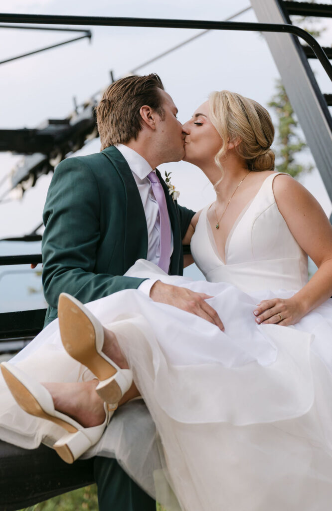 bride and groom kissing on the ski lift cuddling after their mountain ceremony