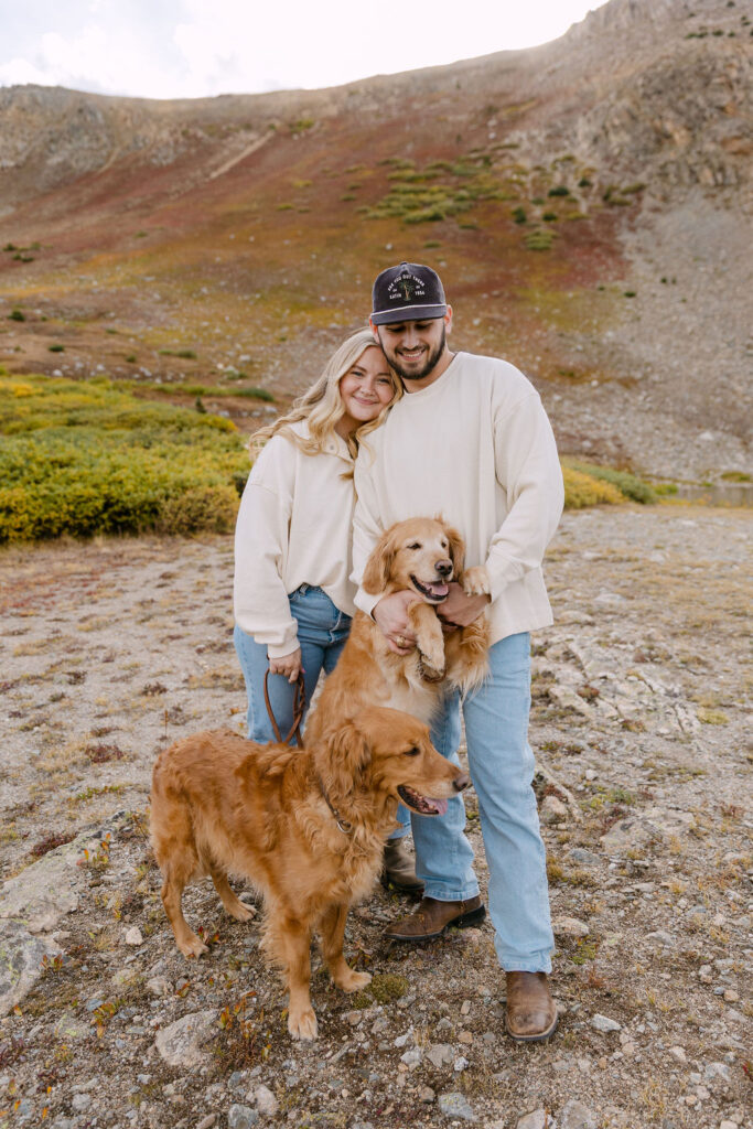 Couple cuddling with their dogs for a colorado engagement session 
