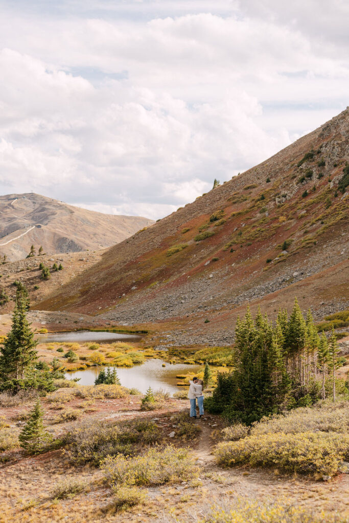 Couple kissing among a vast colorado mountain landscape on Loveland Pass