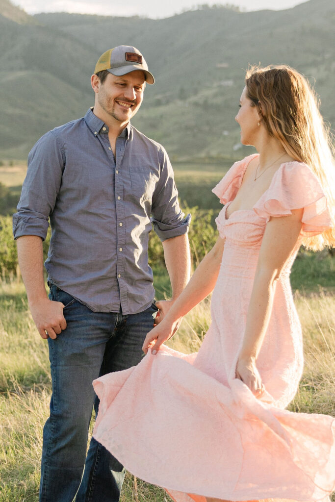 Annelise twirling in her pink dress while Ross watches her with the mountains behind them.