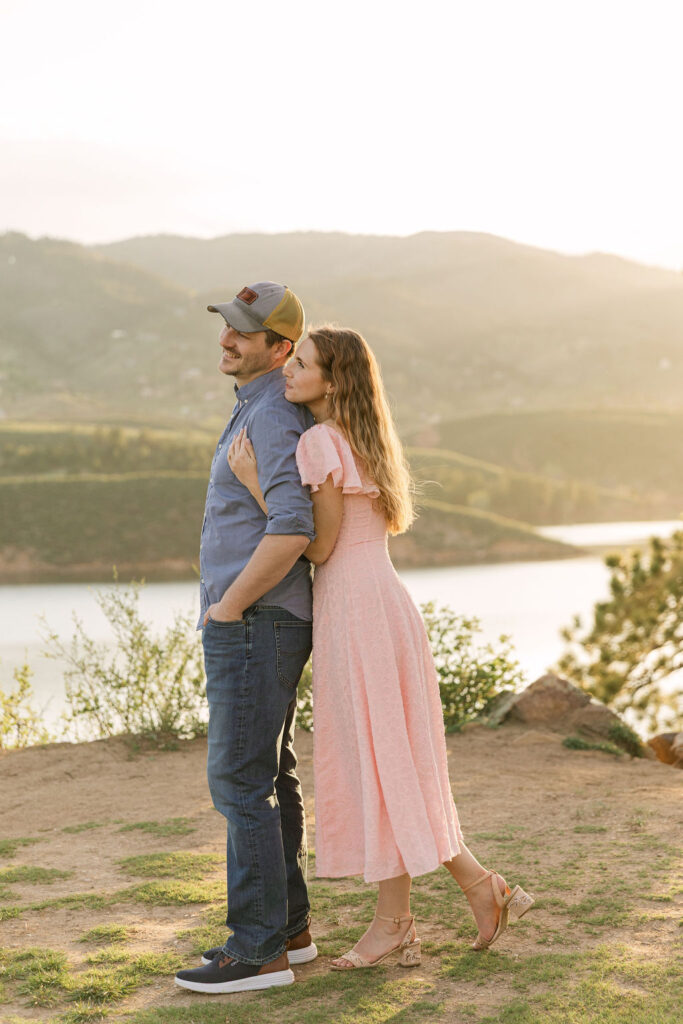 Couple standing together on a hill overlooking the reservoir.