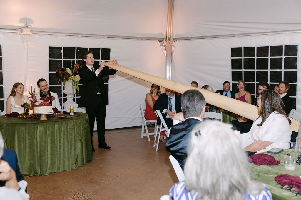 Wedding guest performing a humorous toast using a long scroll at a Colorado reception.