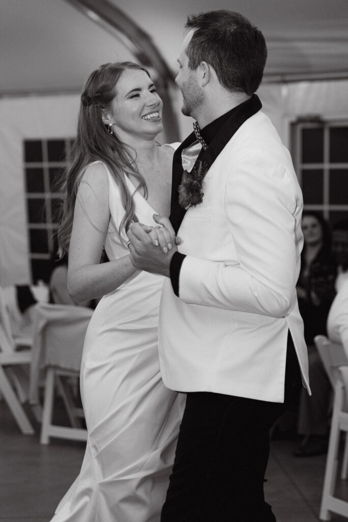 Bride and groom dancing together during their reception under café lights at Hudson Gardens.