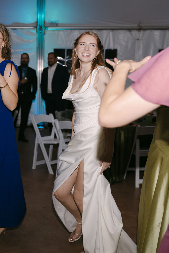 Bride dancing joyfully on the floor during her luxury Colorado garden wedding reception.