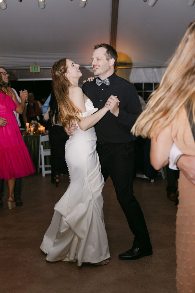 Bride and groom dancing together during an energetic reception at a Colorado wedding venue.