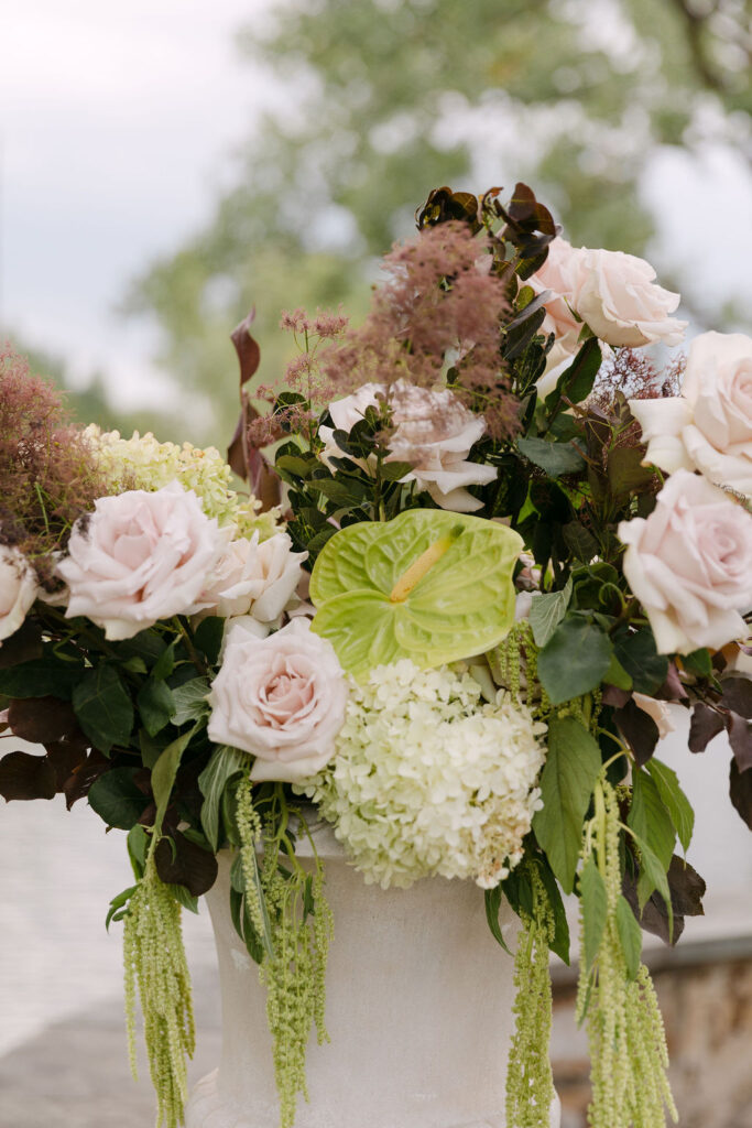 Elegant floral arrangement with blush roses, hydrangea, and burgundy accents for a high-end Colorado wedding at Hudson Gardens.