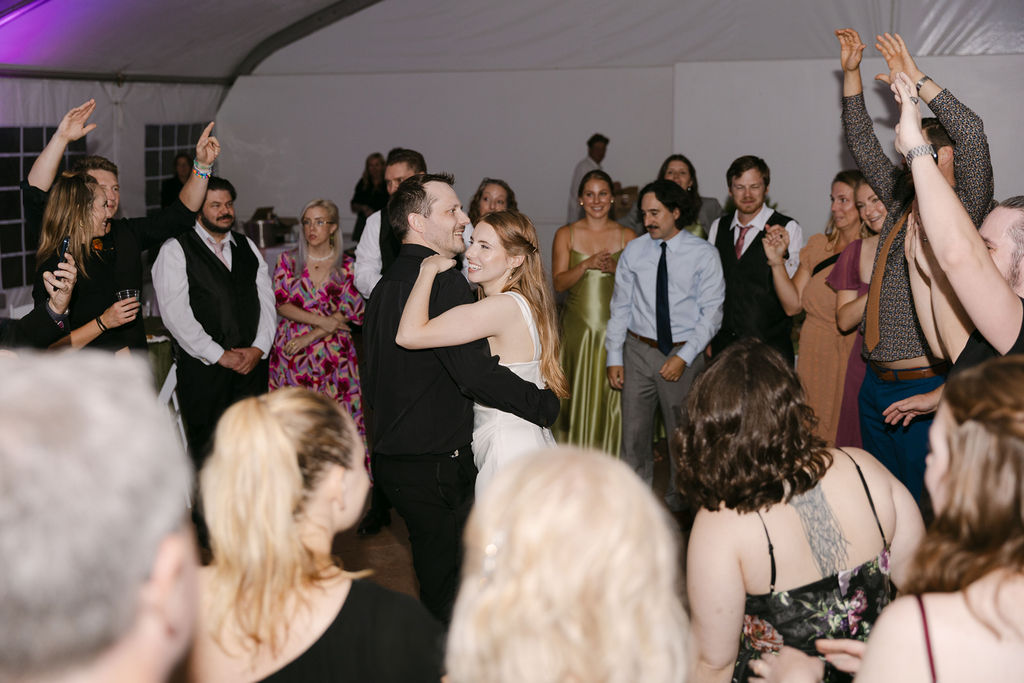 Bride and groom celebrating on the dance floor with guests surrounding them at their luxury Colorado wedding.