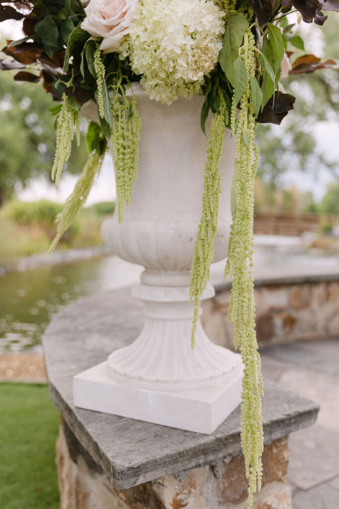 Tall floral centerpiece in classic urn at Hudson Gardens for a high-end Colorado garden wedding.
