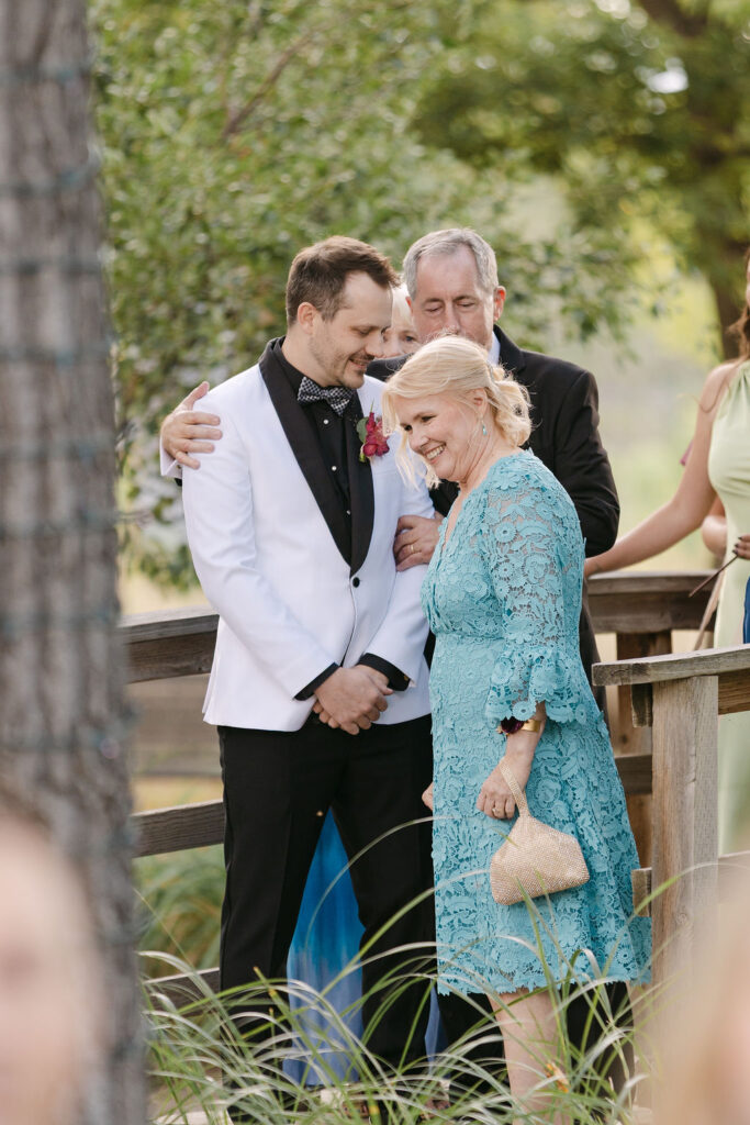 Groom sharing a moment with family before the ceremony at Hudson Gardens in Colorado.