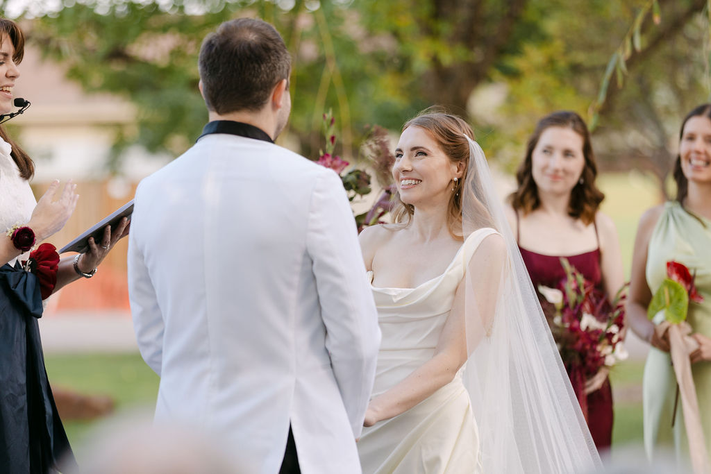 Bride lovingly staring at groom during their Monet's Garden outdoor wedding ceremony.