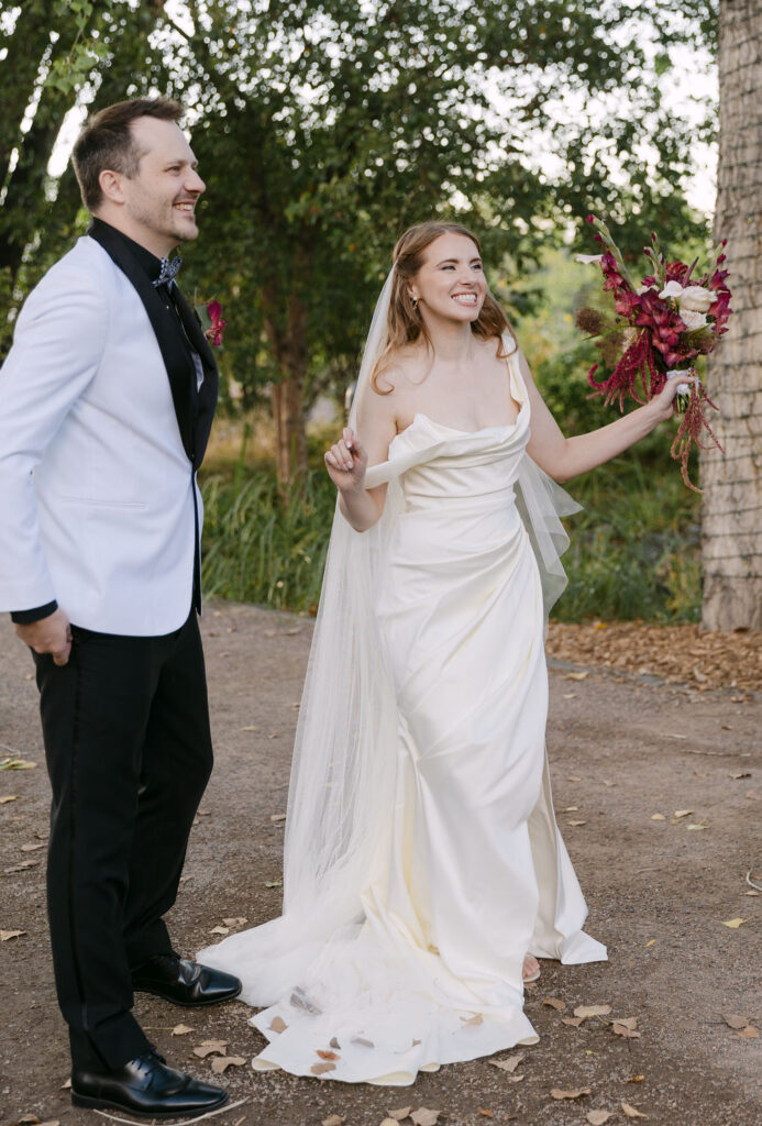 Bride celebrating after the ceremony with bouquet at a Hudson Gardens garden wedding in Colorado.