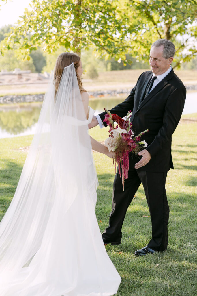 Bride hugging with her father during a first look moment at Hudson Gardens, captured during a Colorado garden wedding.