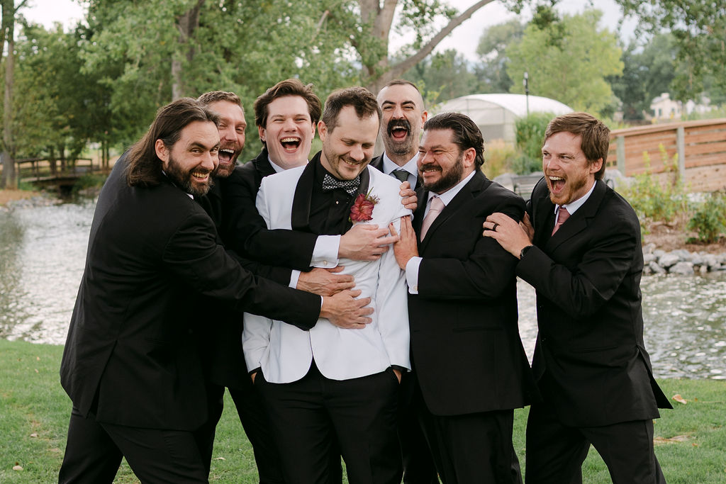 Groom and groomsmen celebrating together at Hudson Gardens in Colorado.