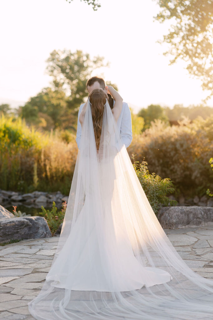 Bride's cathedral length veil at sunset at Hudson Gardens, a fine-art garden wedding location in Colorado.
