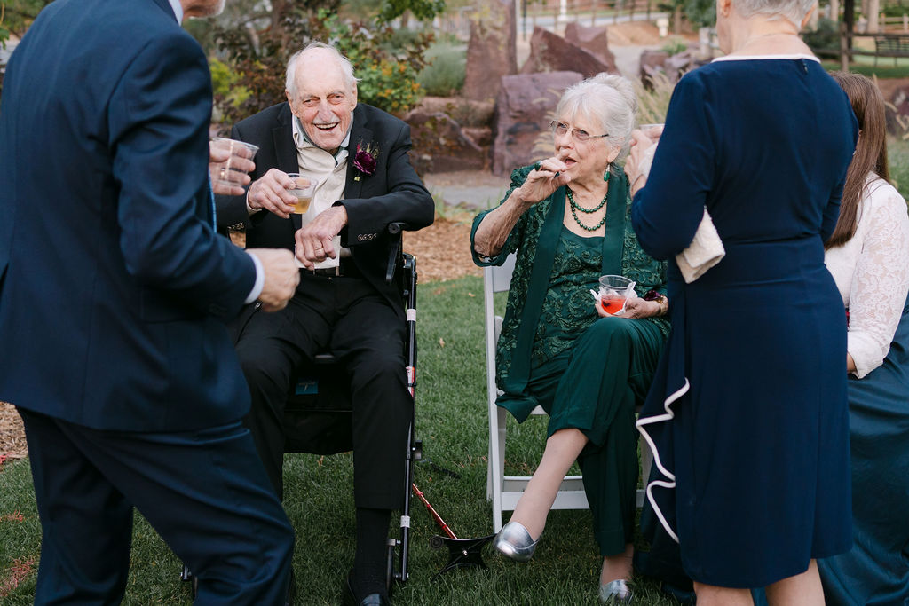 Candid moment of grandparents enjoying cocktails during a luxury Colorado wedding reception.