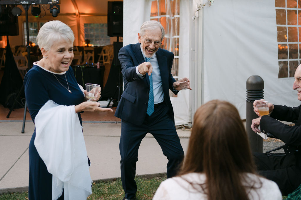 Elderly guest dancing with joyful energy at a high-end Colorado wedding reception at Hudson Gardens.