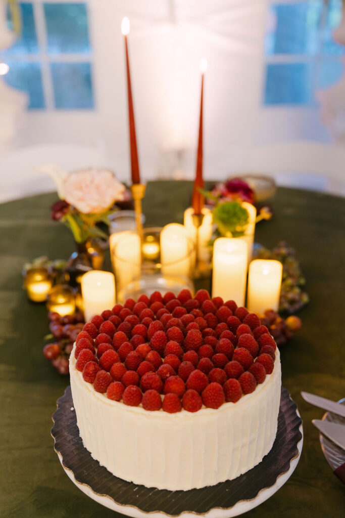 Raspberry-topped wedding cake displayed at a high-end Hudson Gardens reception.
