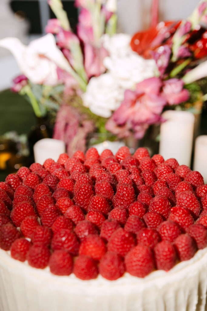 Close-up of raspberry-covered wedding cake for an elegant Colorado garden wedding reception.