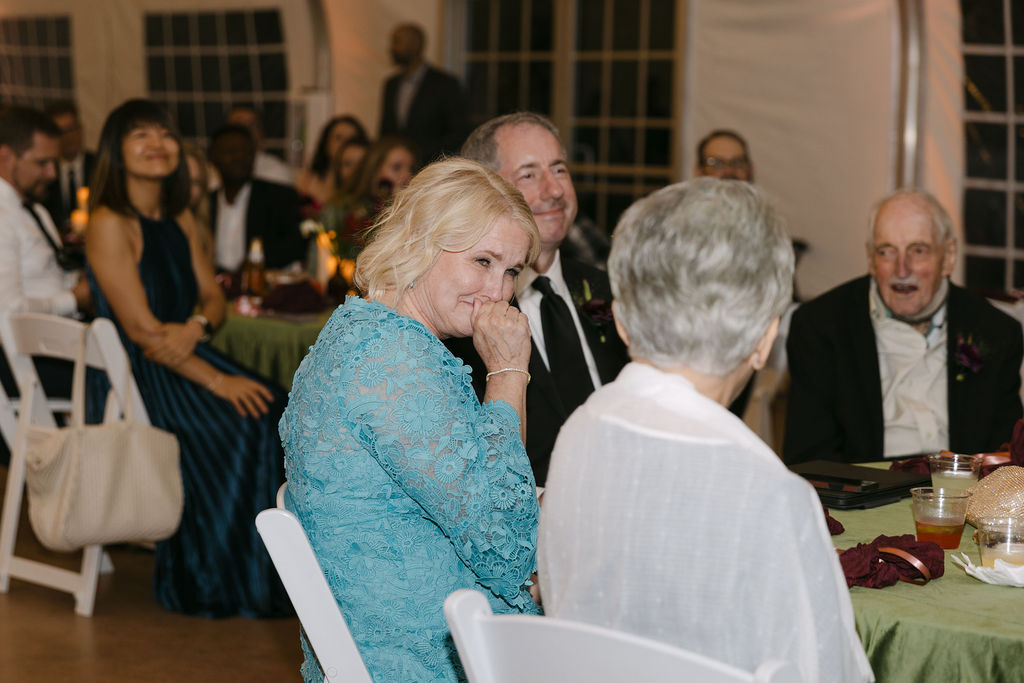 Mother of the bride wiping away tears during toasts at a Hudson Gardens reception.